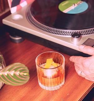 Rythmik Great Taste Award-winning Maple Old Fashioned cocktail next to a vinyl record player