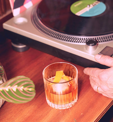 Rythmik Great Taste Award-winning Maple Old Fashioned cocktail next to a vinyl record player