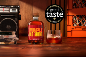 Rythmik 2026 Great Taste Award-winning Maple Old Fashioned bottled cocktail next to a short glass with a clear ice cube.